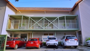 A building with a covered entrance and three cars parked in front. - Riverscapes By Noorjehan (Palakkad)