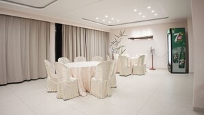 A conference room with a round table, white chairs, and a 7UP refrigerator. - Riverscapes By Noorjehan (Palakkad)