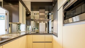 Una cocina moderna con electrodomésticos de acero inoxidable, una isla central y vistas al exterior.