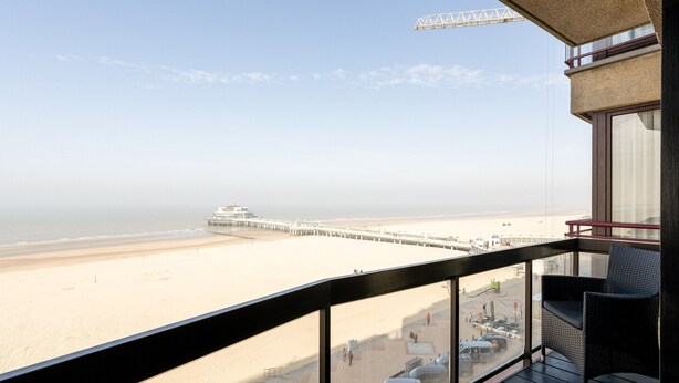 A balcony with a view of a beach and pier. - Apartment in Blankenberge with Sea View (Blankenberge)