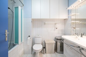 Ein modernes Badezimmer mit Toilette, Waschbecken und Dusche.