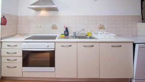 Une cuisine équipée d’une cuisinière, d’un four, d’un évier et de placards.