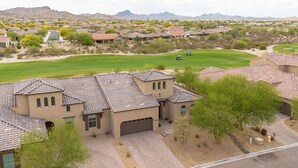 A residential area with houses featuring terracotta roofs and stucco walls, surrounded by a golf course and desert landscape. - EAZY AZ Modern 2 bedroom townhouse on the 8th fairway of Estrella Mountain Ranch (Goodyear)