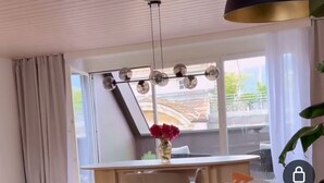 A modern living room with a sofa, a dining table, and a pendant light. - Maison Züri Charming Retreat in Wiedikon, Just 16 Minutes from Lake Zurich (Zürich)