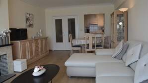 Una sala de estar con sofá, una mesa de centro y un comedor con mesa y sillas.