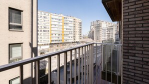 Blick vom Balkon auf eine Baustelle mit mehreren Gebäuden im Hintergrund.