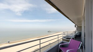 Uma varanda com vista para a praia e o cais.