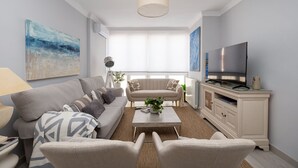 Una sala de estar moderna con un sofá, sillones, una mesa de centro y un televisor.