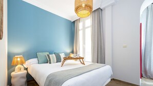 A bedroom with a bed, bedside tables, a lamp, and a window with curtains. - ChezmoiHomes Gran Vía 47 (Granada)