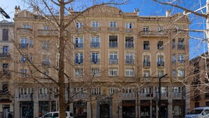 Um edifício de vários andares com estilo arquitetônico clássico, com varandas e janelas amplas.