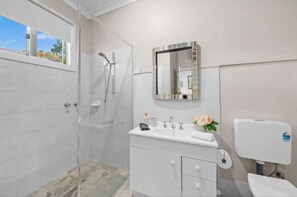 Ein Badezimmer mit Dusche, Toilette und Waschbecken.