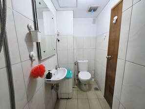 A small bathroom with a white sink, a toilet, and a mirror.