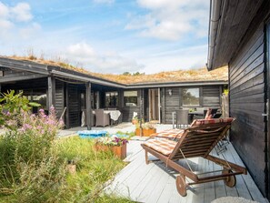 A wooden deck with outdoor furniture and a hot tub.
