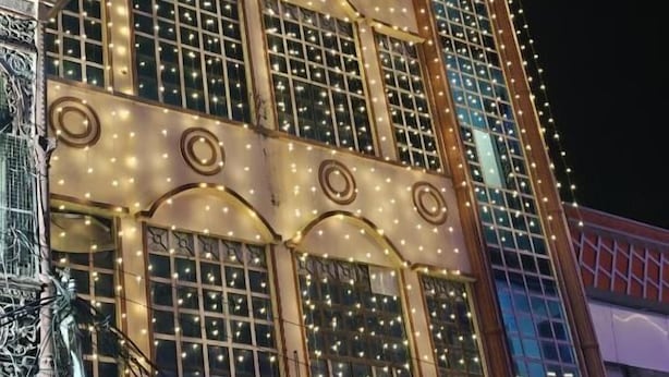 A building with multiple windows adorned with string lights, creating a festive atmosphere. - kailash pati guest house (Varanasi)