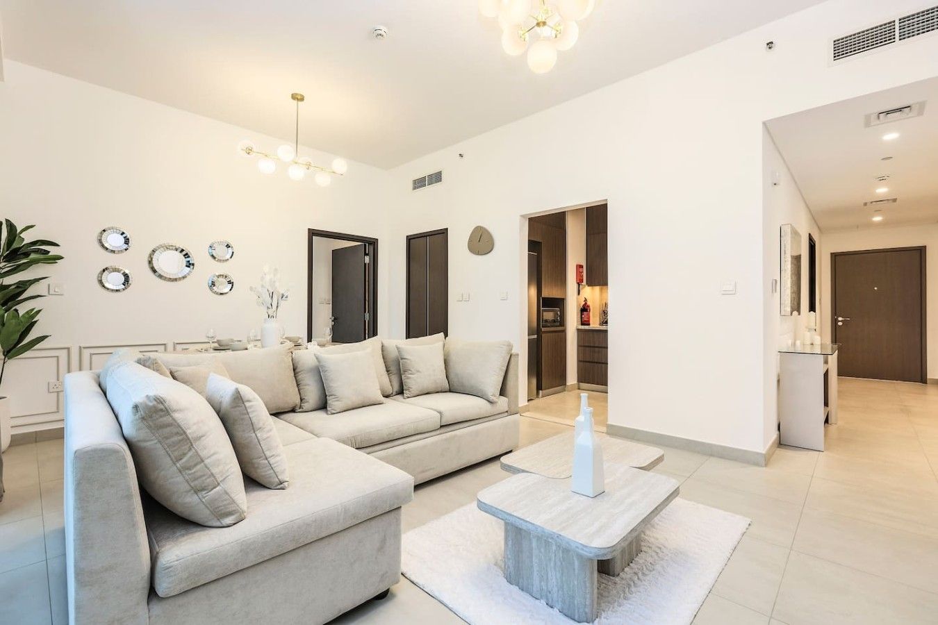 A modern living room with a sofa, a coffee table, and a dining area.