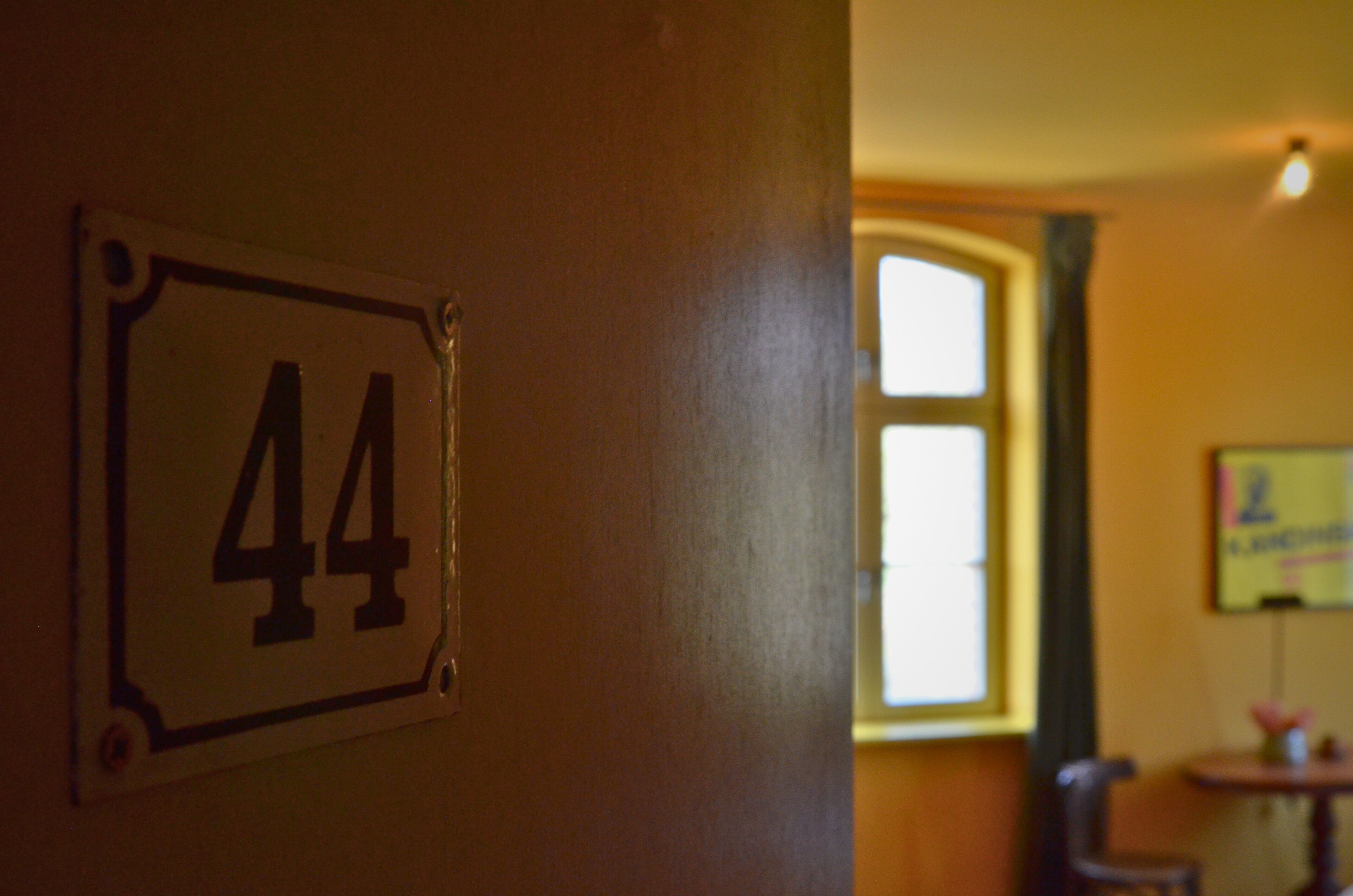 Een kamer met een deur waarop '44' staat.