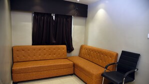 Una habitación con un sofá modular y una silla de oficina negra.