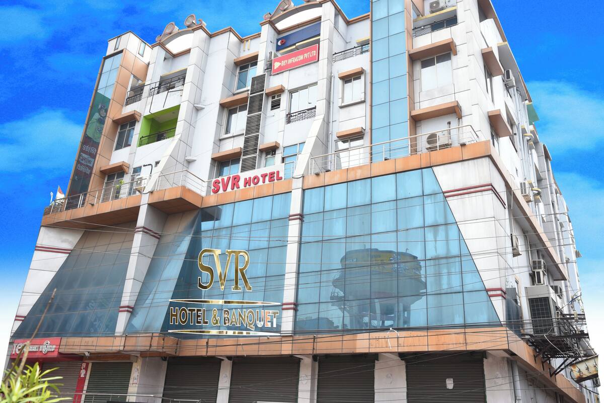 Un hôtel à plusieurs étages, reconnaissable à son grand panneau indiquant « SVR HOTEL & BANQUET ».
