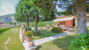 A house with a paved pathway leading to the entrance, surrounded by lush greenery and trees. - Stunning home in Camaiore with WiFi (Camaiore)