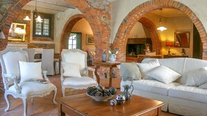 A living room with white furniture, brick arches, and a fireplace. - Lovely home in Terranuova Bracciolini (Terranuova Bracciolini)