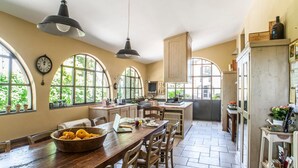 A spacious kitchen with large arched windows, wooden furniture, and a rustic aesthetic. - Lovely home in Terranuova Bracciolini (Terranuova Bracciolini)