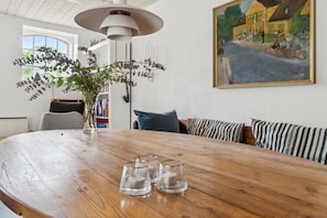 A dining table with three glasses, a hanging plant, and a painting on the wall. - Scenic area close to forest golf and beach (Rønne)