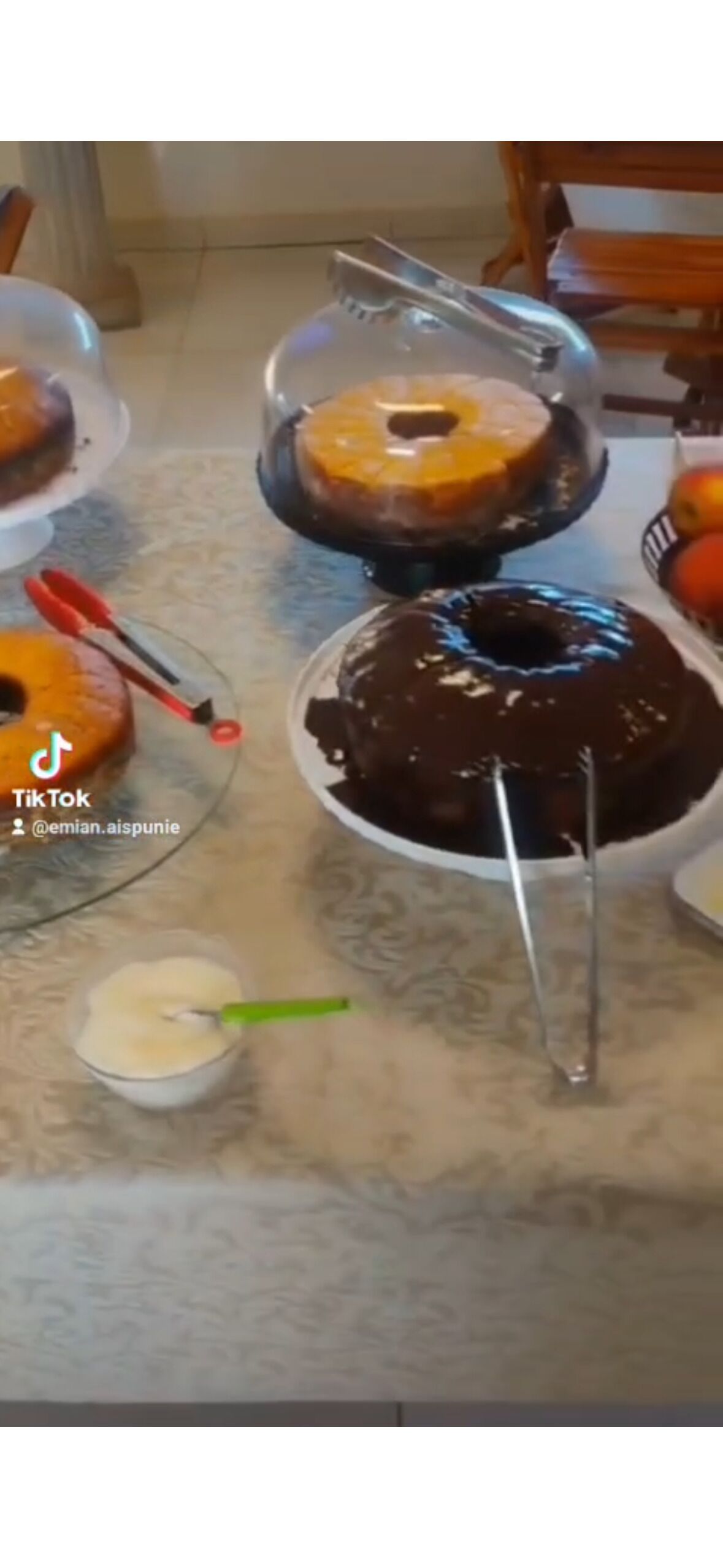 A table with various desserts, including cakes and a chocolate-covered item, with a spoon in a small bowl.