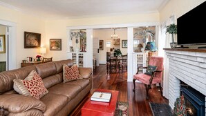 Un salon avec un canapé en cuir marron, une table basse rouge et une cheminée.