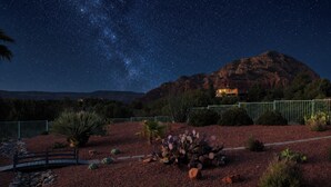 A night scene with a starry sky, a mountain, and a building with lights. - Sedona Infinity Pool Paradise | Red Rock Views | Hot Tub (Sedona)