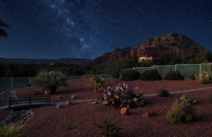 A night scene with a starry sky, a mountain, and a building with lights. - Sedona Infinity Pool Paradise | Red Rock Views | Hot Tub (Sedona)