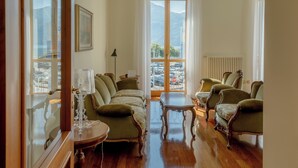 A spacious living room with a large window, a sofa set, and a coffee table. - Casa MAMMA, family relaxation on Lake Iseo - elegant apartment - 2 rooms (Lovere)