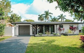 A modern two-story house with a garage, a paved driveway, and a well-maintained lawn.