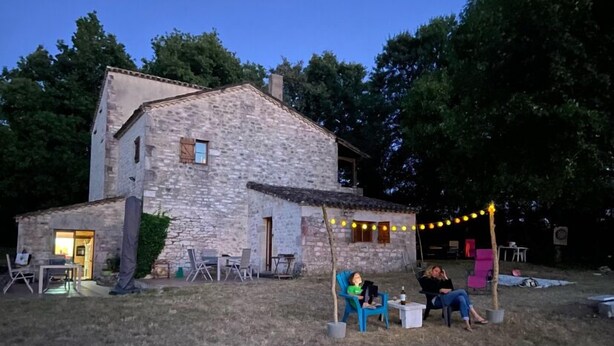 A stone house with a patio area, outdoor seating, and string lights. - 5 Bedroom Villa in Montcuq en quercy (Montcuq en quercy)