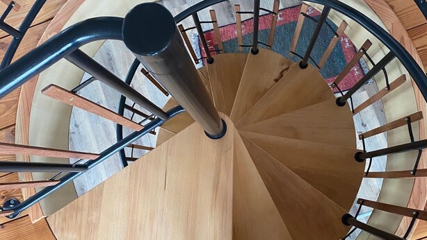 A spiral staircase with wooden steps and metal railings. - Modern vacation home that leaves nothing to be desired at the Eifel National Park (Hürtgenwald)