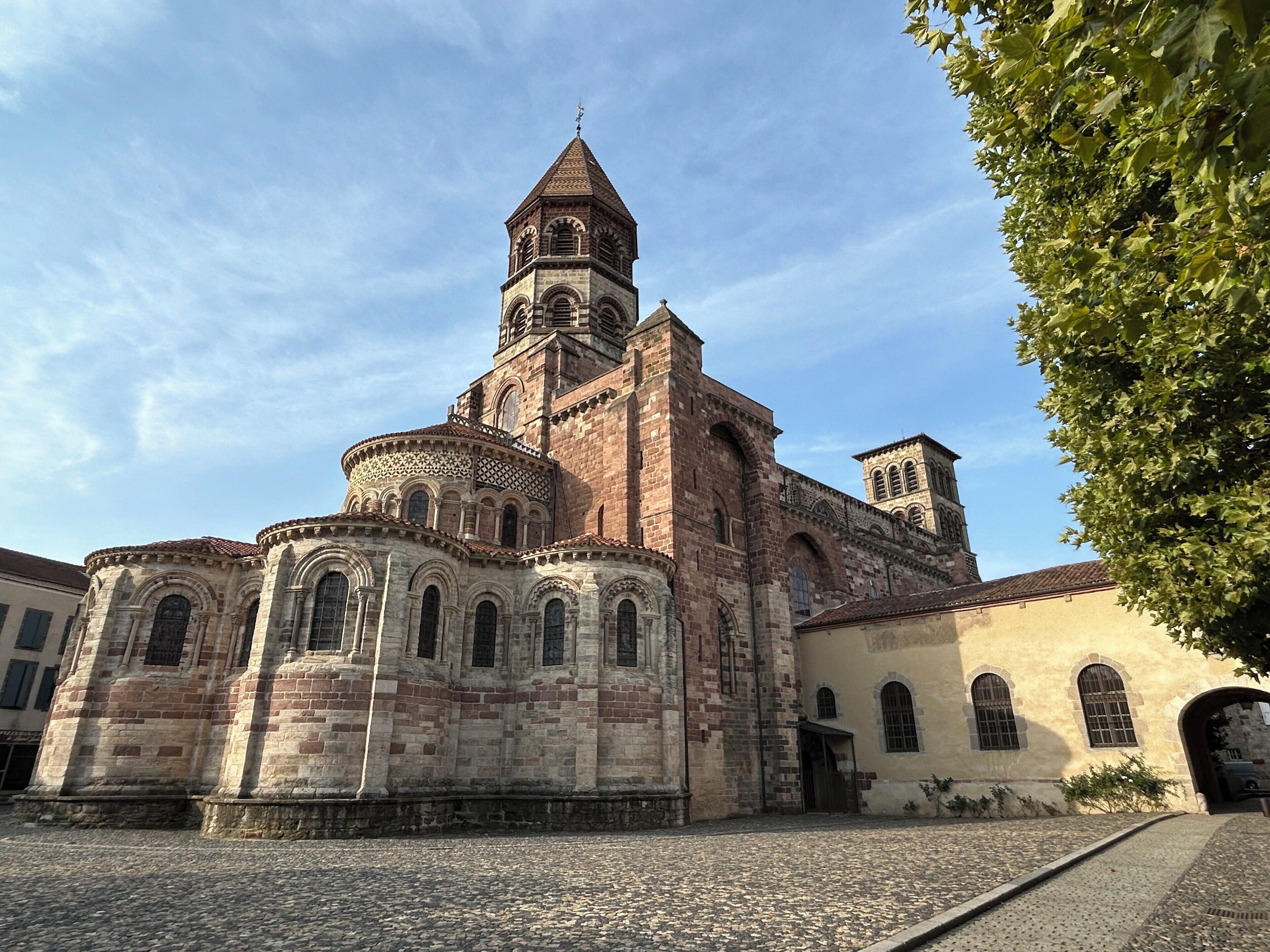 Uma igreja histórica com uma torre de sino imponente e janelas em arco.