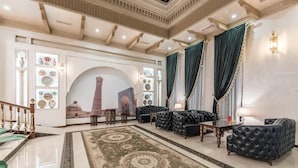 Una lussuosa hall con un’imponente scalinata, confortevoli posti a sedere e decorazioni elaborate.