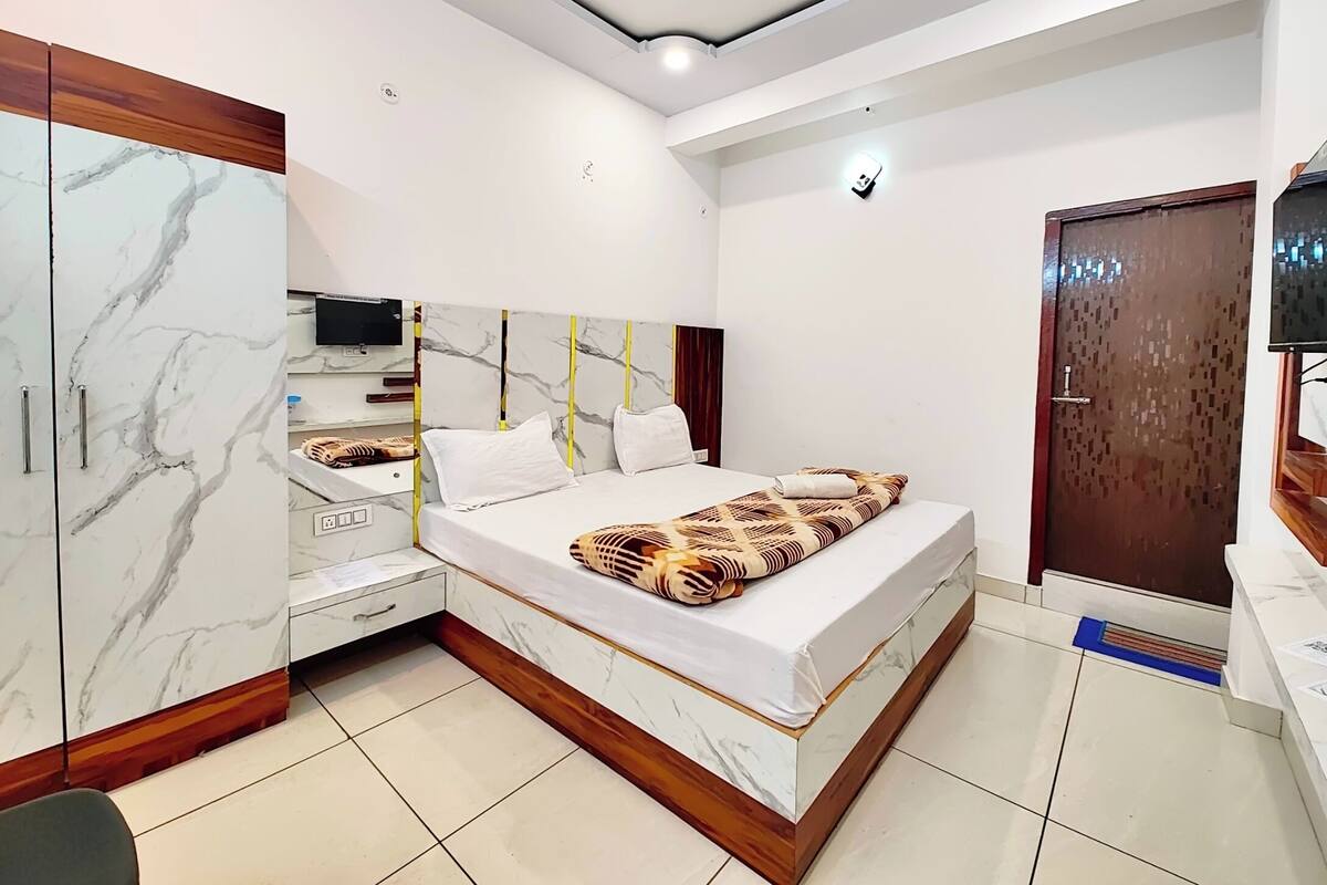 Ein Schlafzimmer mit Bett, Kleiderschrank, Fernseher und einer Tür.