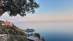 A coastal view with a church on a hillside, overlooking the sea.
