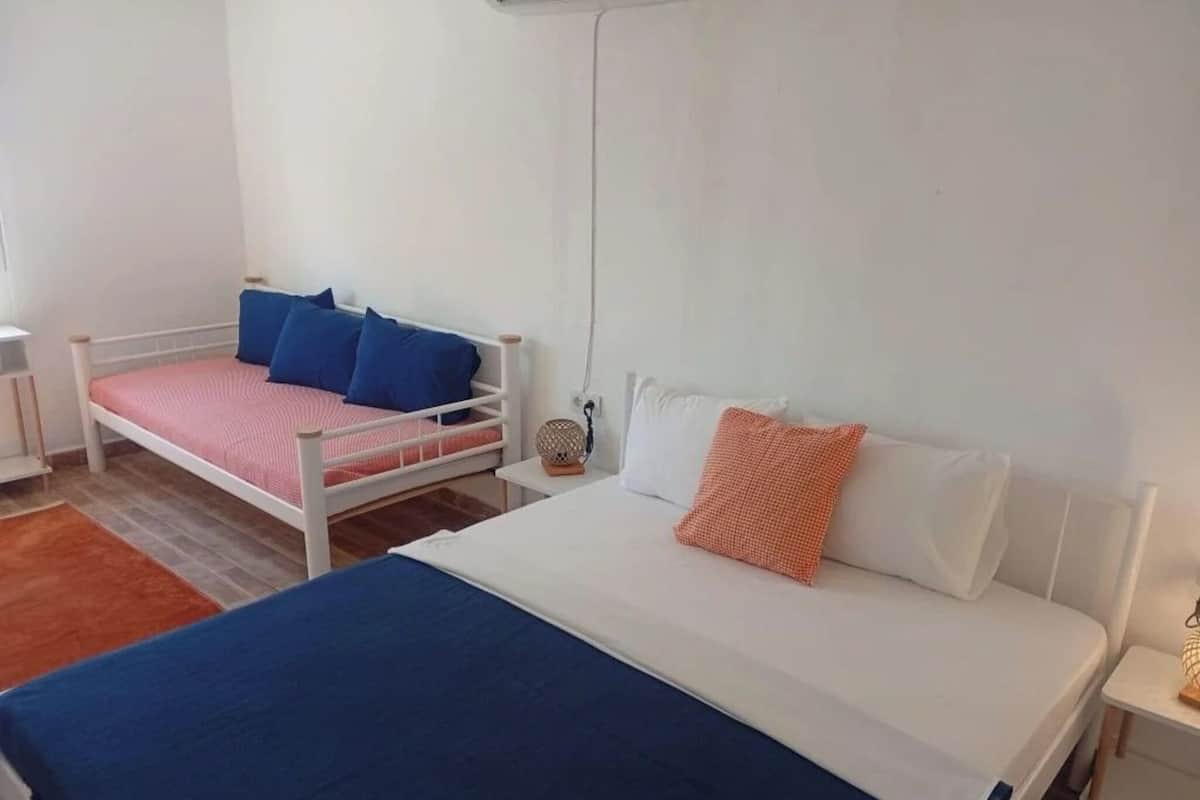 Ein Schlafzimmer mit einem Einzelbett, einem Nachttisch, einer Lampe und einem kleinen Tisch.