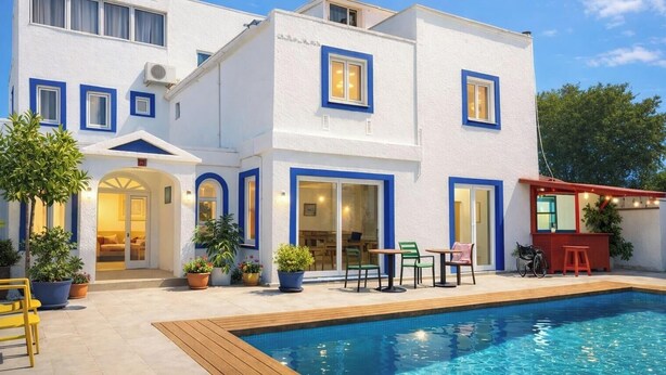 A two-story building with a swimming pool, outdoor seating, and potted plants. - Kavala Hotel Bodrum (Bodrum)
