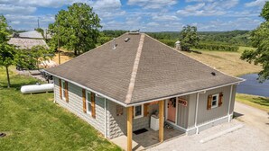 Un bâtiment d’un seul étage, doté d’un toit en pente, d’un porche couvert et d’une petite remise attenante.