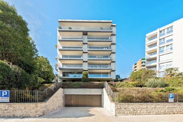 Un edificio residenziale a più piani con balconi, un ingresso con cancello e un segnale che indica parcheggio riservato.