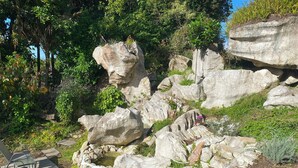 A rocky garden with large boulders and a small pond.