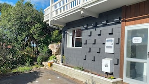 A building with a grey brick exterior, a white balcony, and a window with a sign that reads "Imortone Audio".