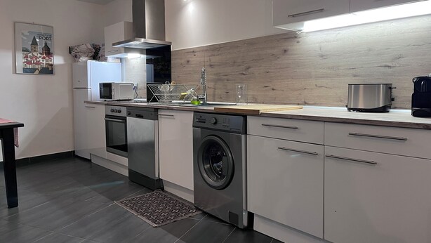 Una cocina moderna equipada con lavavajillas, horno, microondas y cafetera.