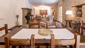A dining area with a wooden table, chairs, and a chandelier. - Villa Roncaglia by MMega (Fratte Rosa)