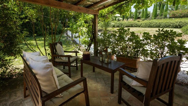 An outdoor patio with wooden furniture, a table, and a pergola. - Villa Roncaglia by MMega (Fratte Rosa)