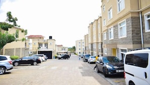 Eine Wohnstraße mit parkenden Autos und mehrstöckigen Gebäuden.