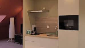 A modern kitchen with a built-in Bosch refrigerator, a stainless steel sink, and a wooden slatted ceiling.