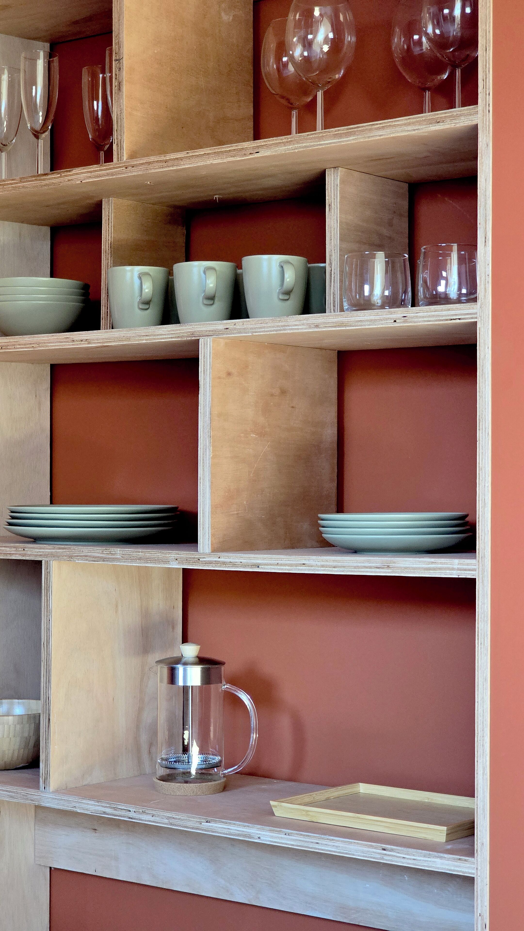 Une étagère en bois sur laquelle sont disposés divers objets en verre et en céramique.